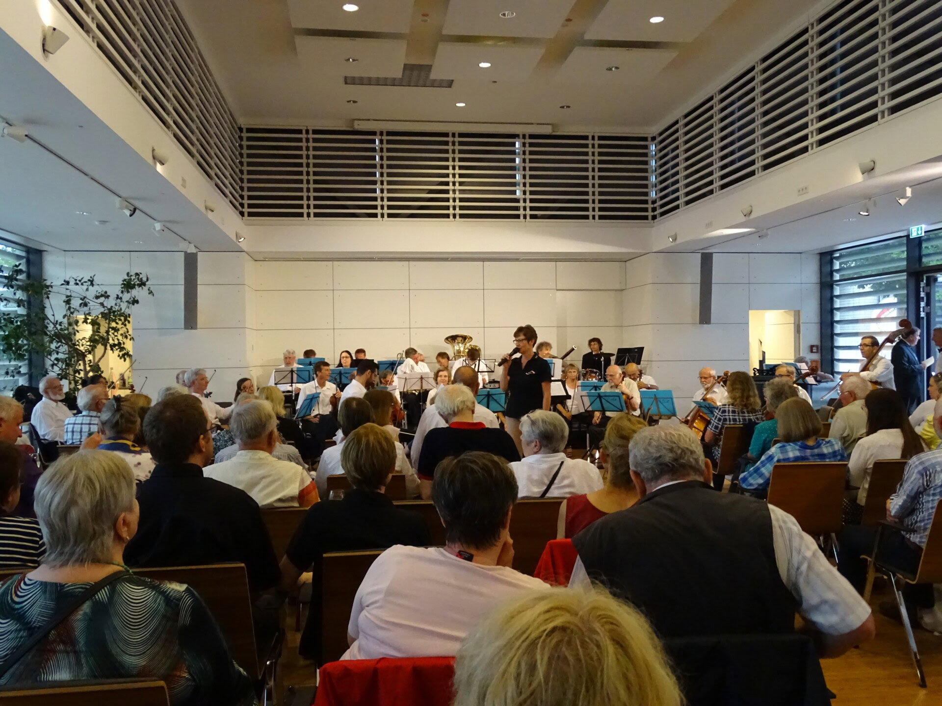 Konzert mit Orchester in einem modernen Saal.