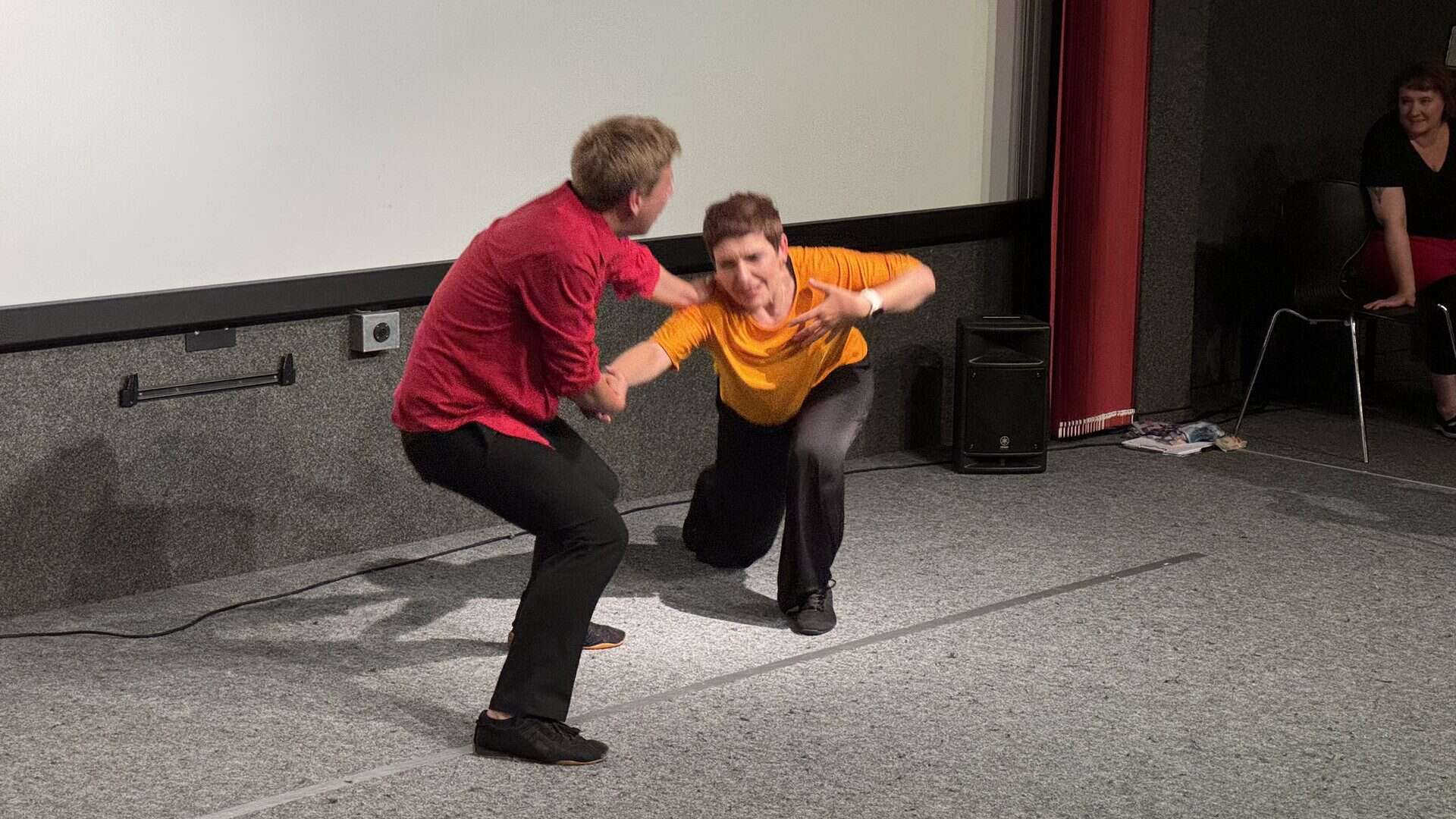 Tanzperformance auf Bühne mit zwei Personen.