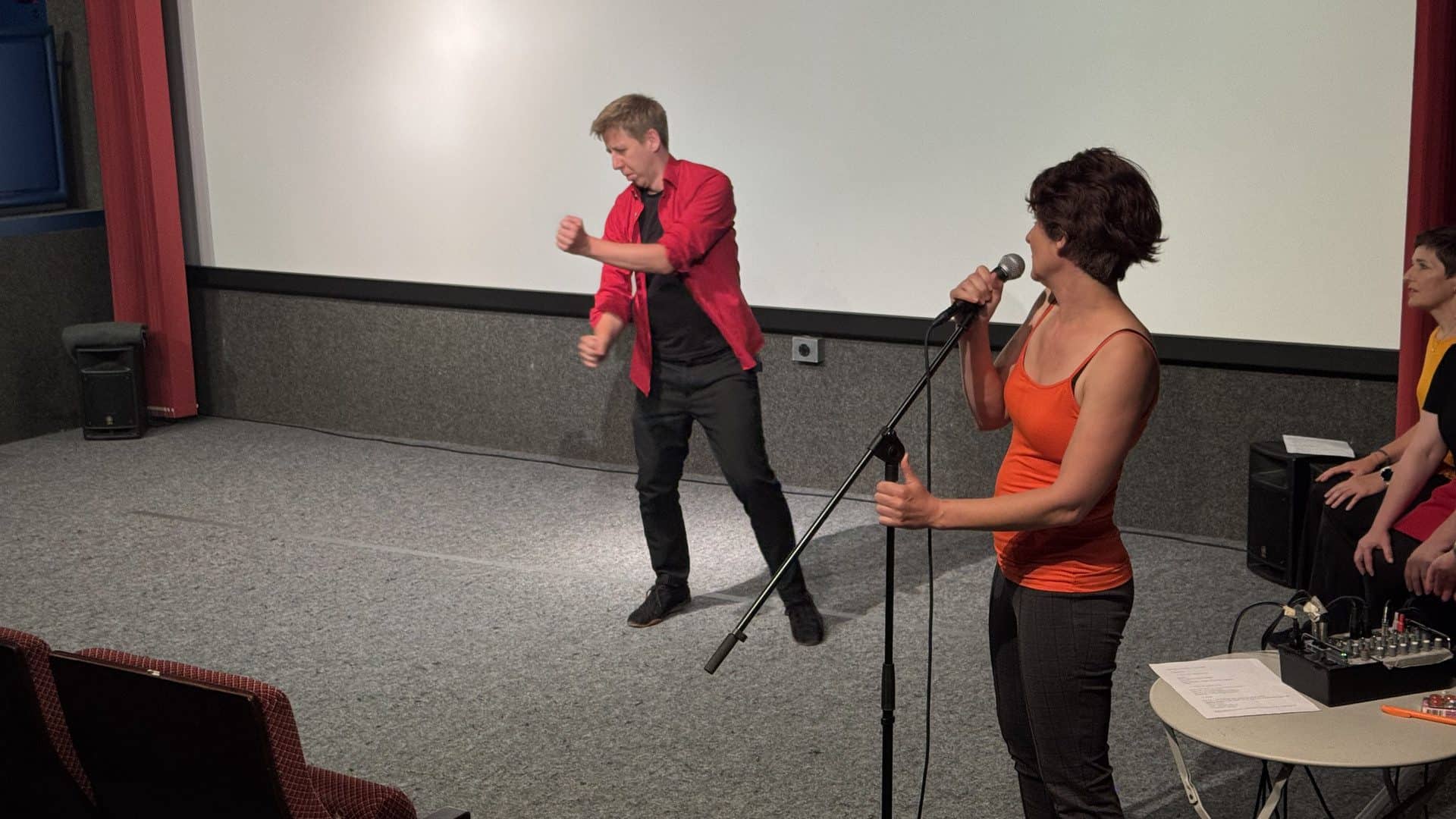 Menschen im Theater mit Mikrofon bei Performance