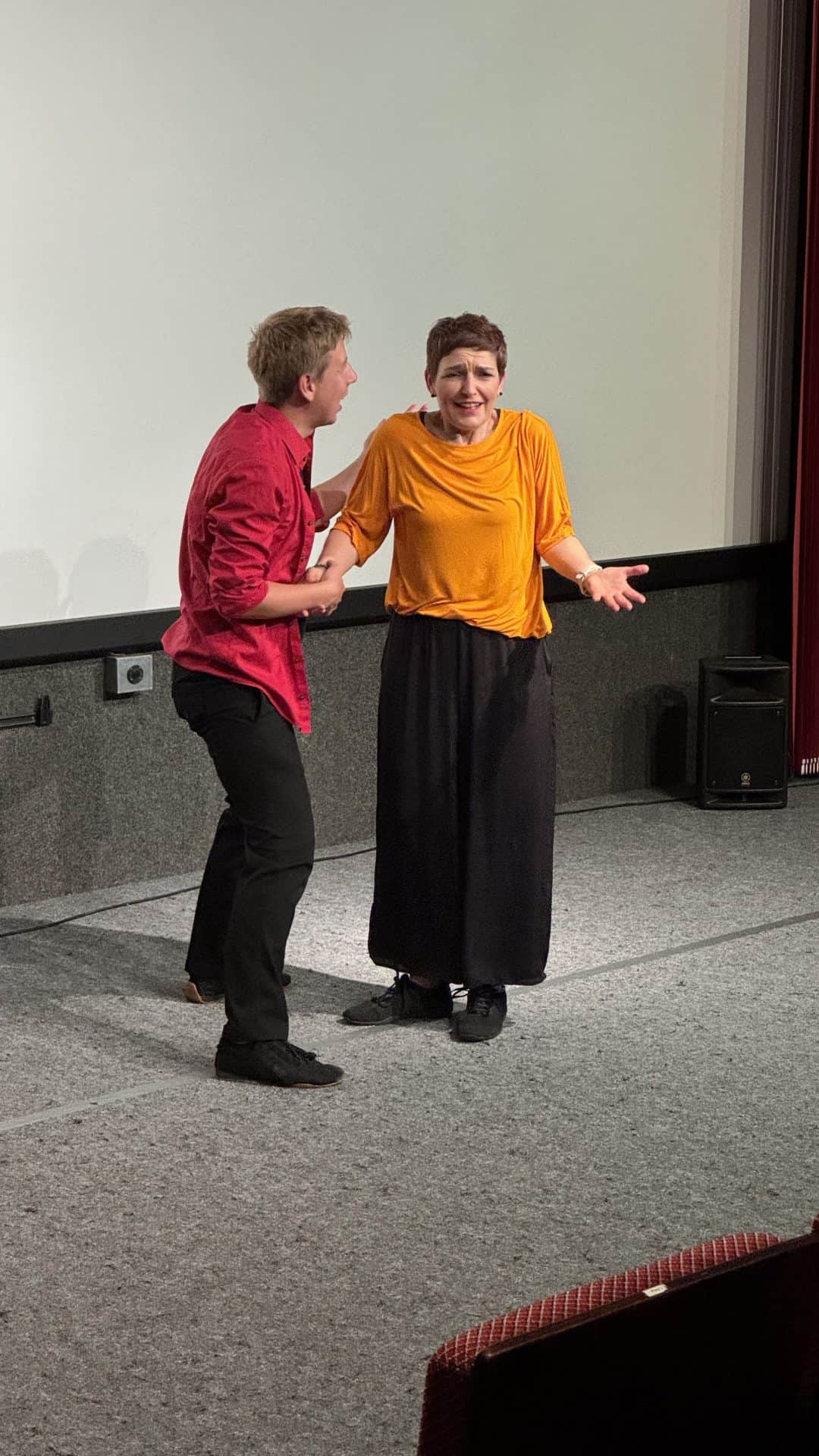 Zwei Personen auf der Bühne in einer Theateraufführung.