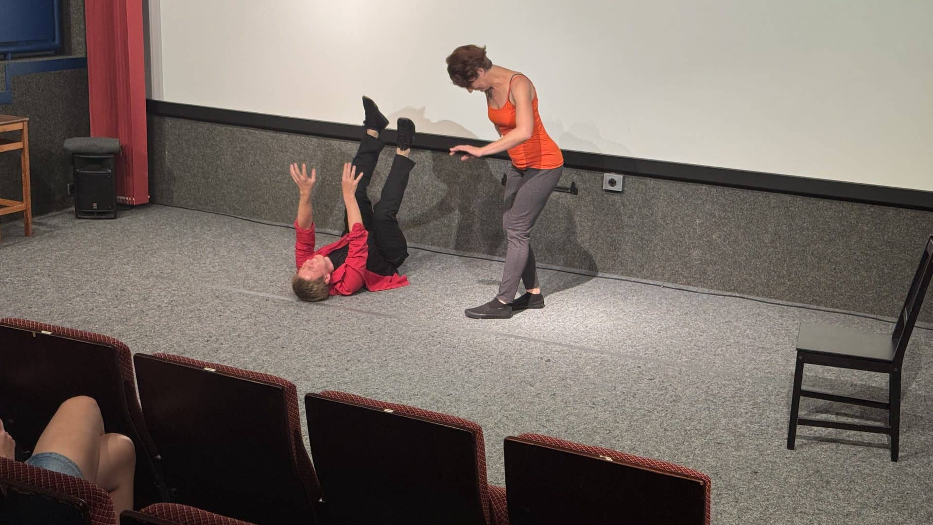 Schauspieler führen auf einer Bühne eine Szene auf.