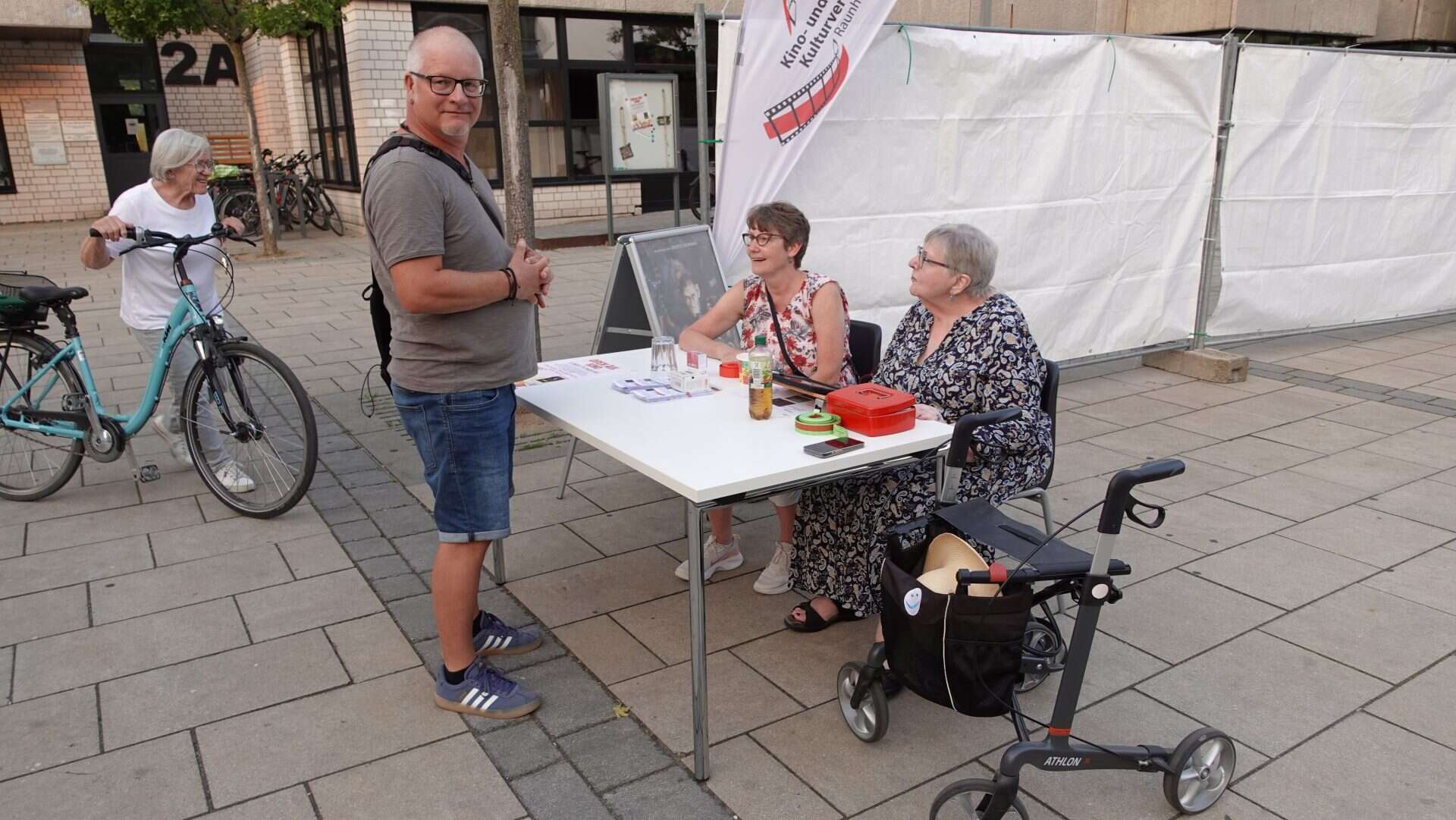 Menschen an Infostand auf öffentlichem Platz.
