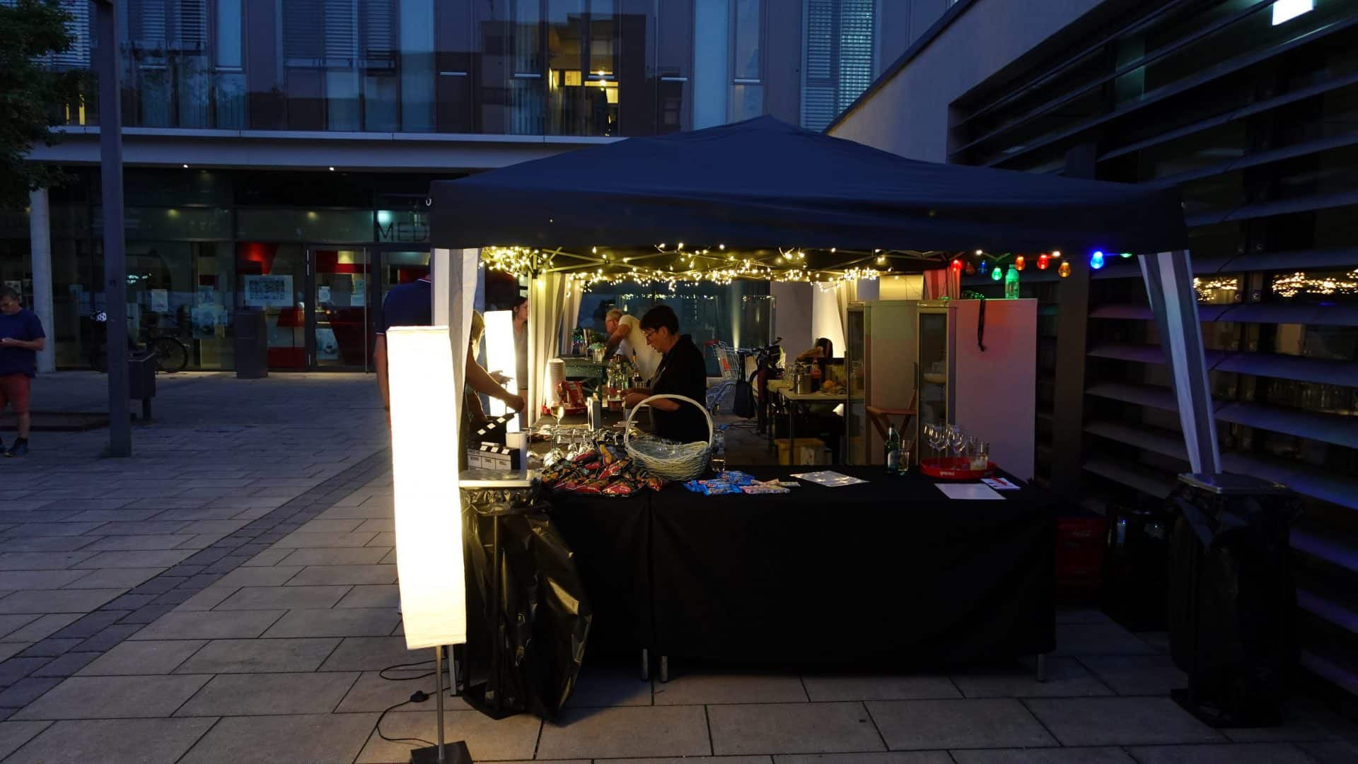 Nachttisch mit Lichtern und Snacks auf Stadtplatz