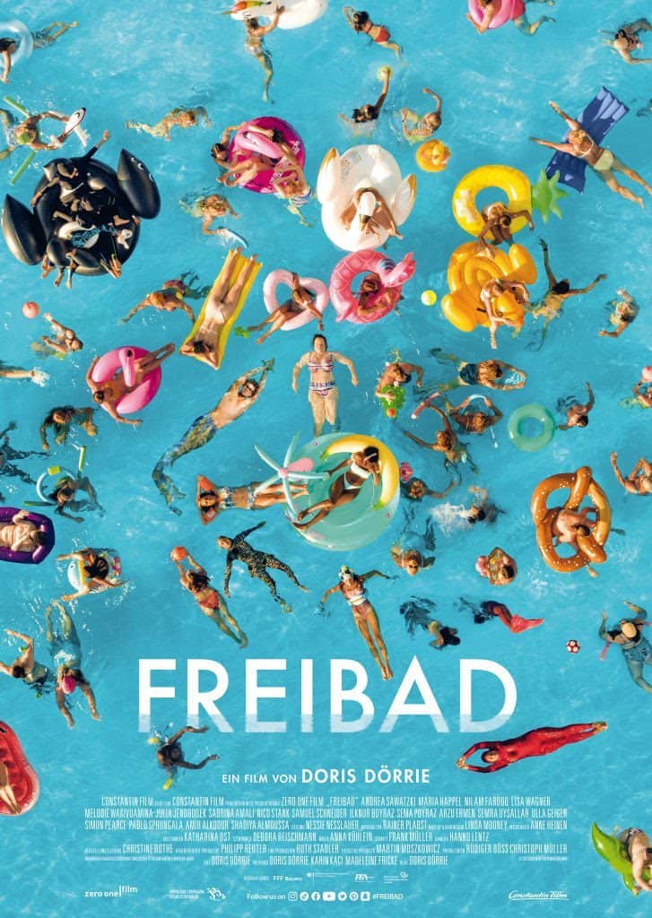 Menschen mit Schwimmreifen im Freibad.