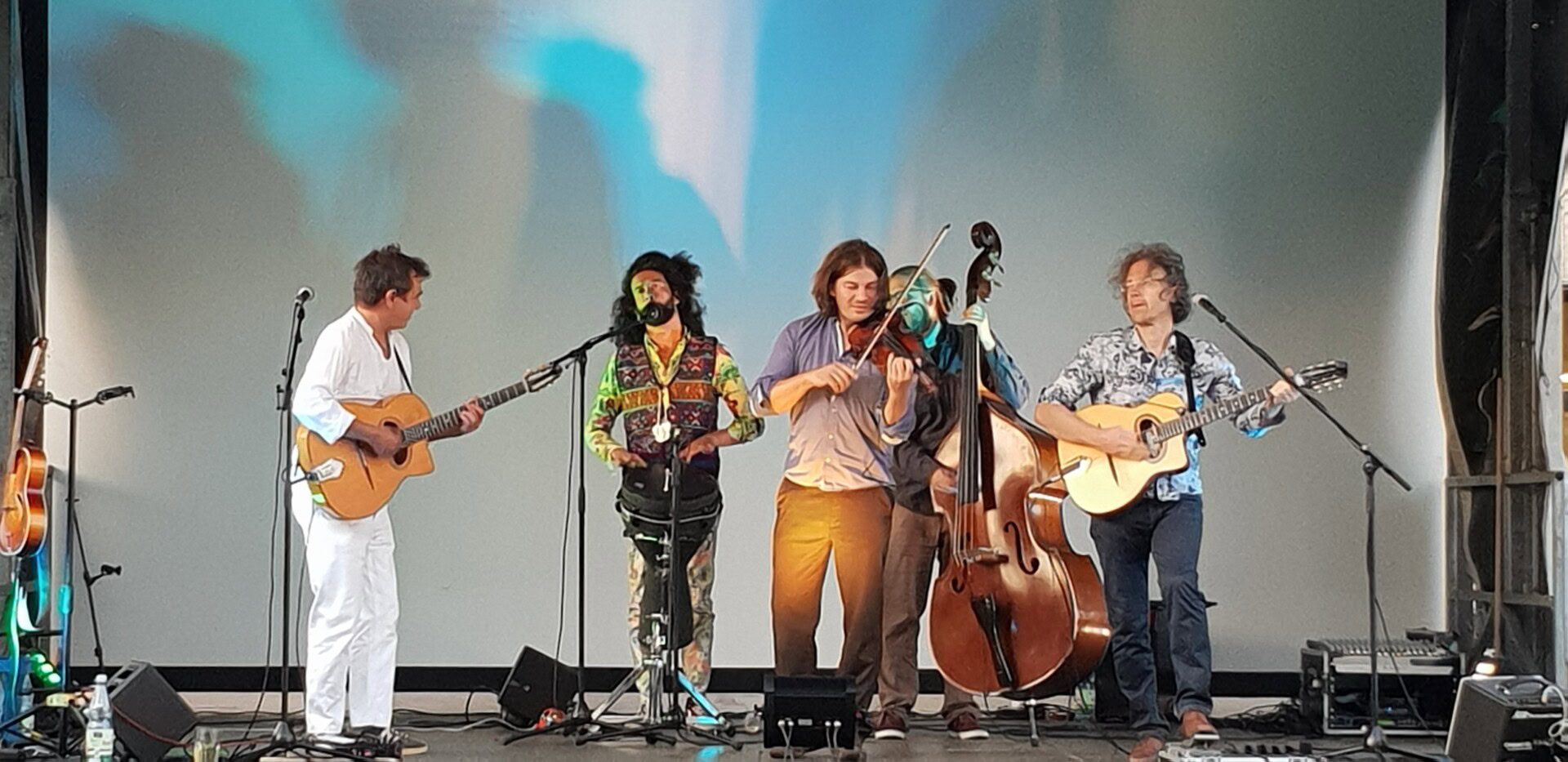 Musikband spielt auf der Bühne mit Instrumenten.