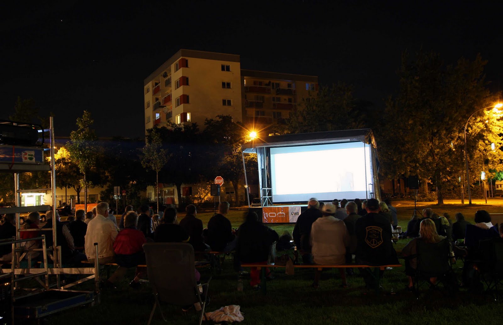 Freiluftkino bei Nacht, Zuschauer auf Bänken