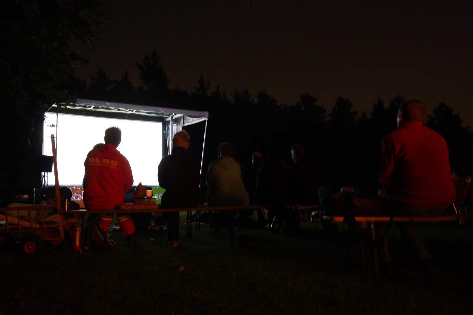 Nachtkino im Freien mit sitzendem Publikum