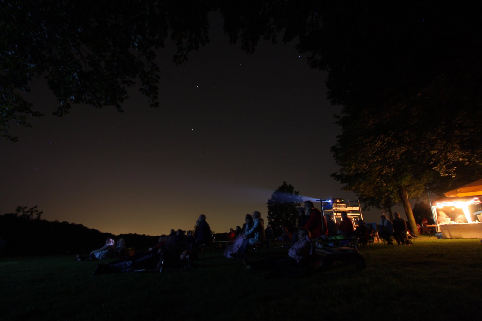 Menschen schauen nachts Filme im Freien