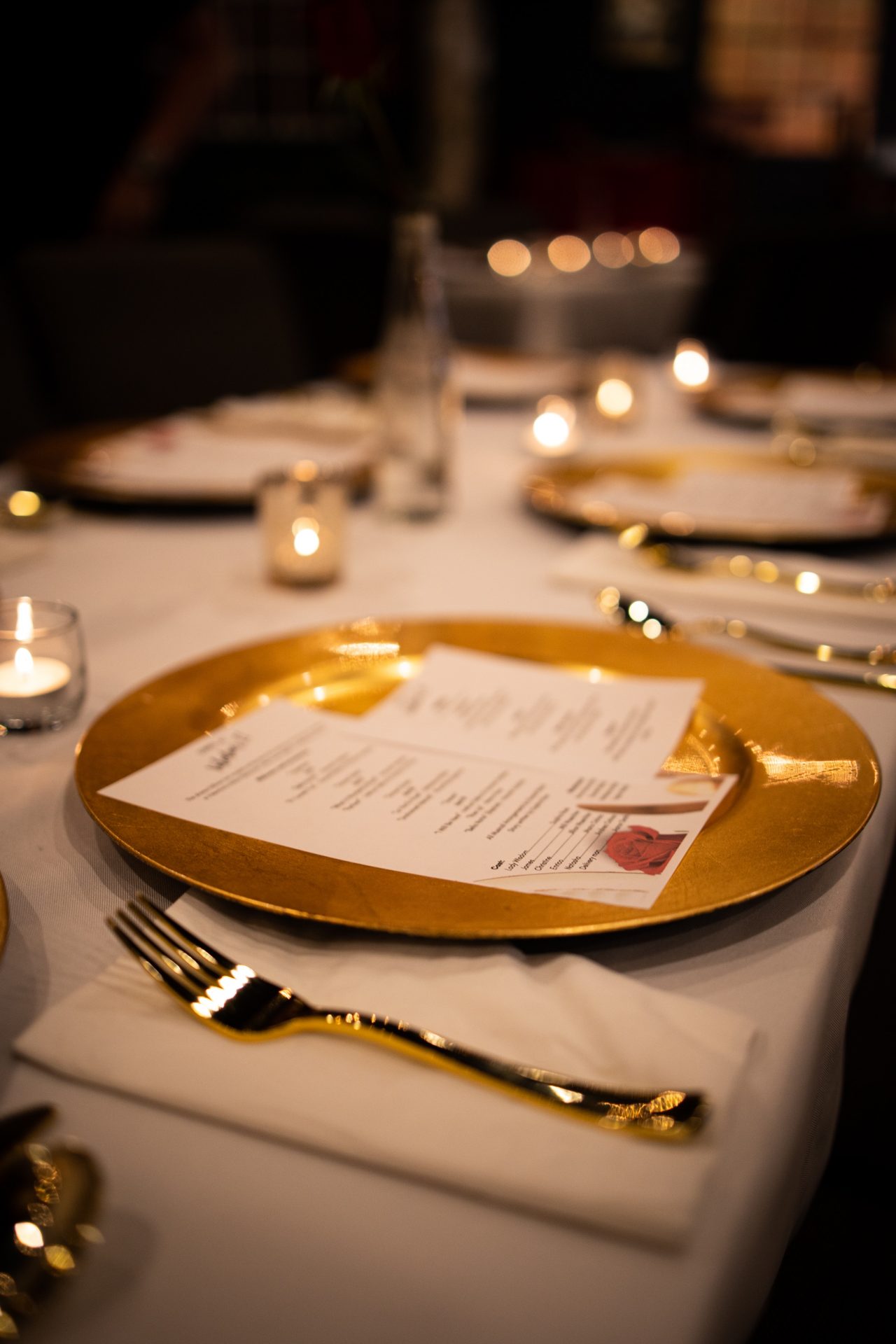 Elegantes Abendessen mit Kerzenlicht und Menükarten.