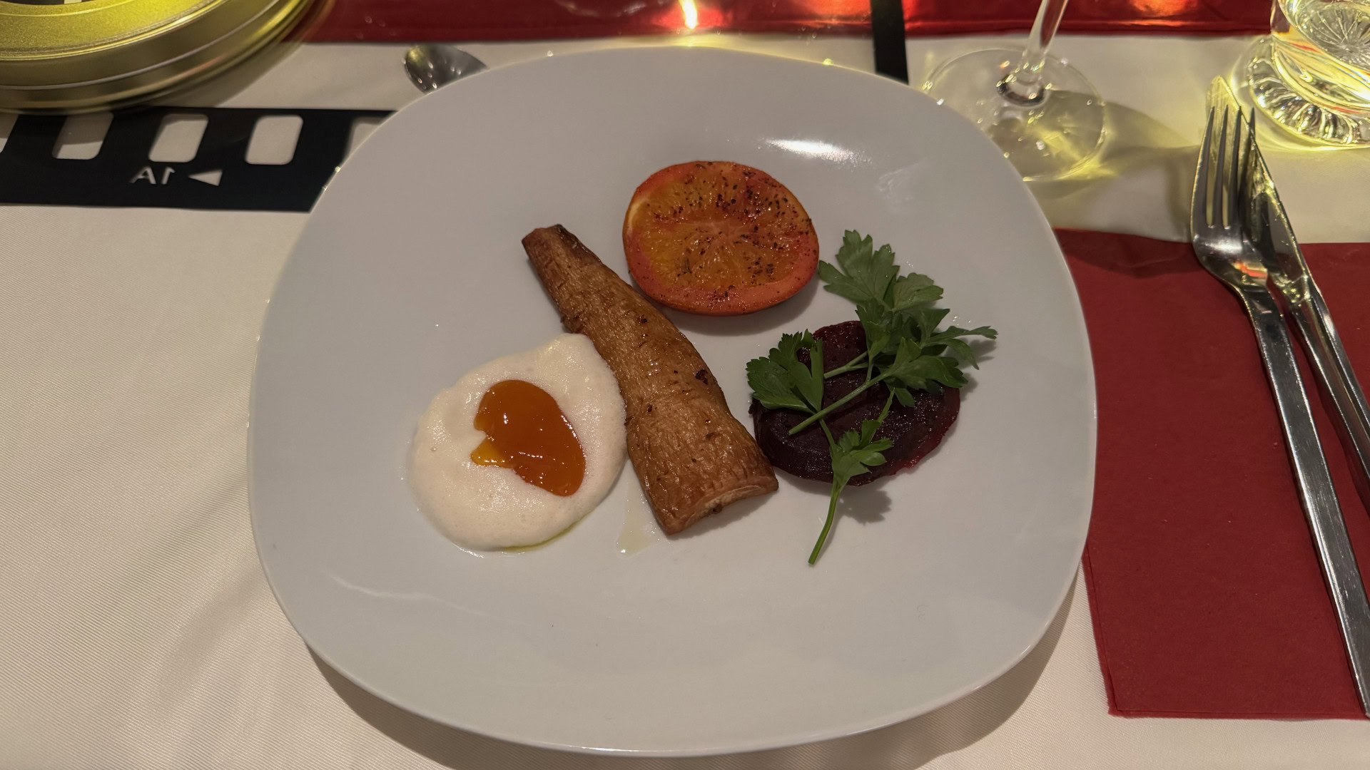 Gourmetgericht mit Gemüse und Sauce auf weißem Teller.