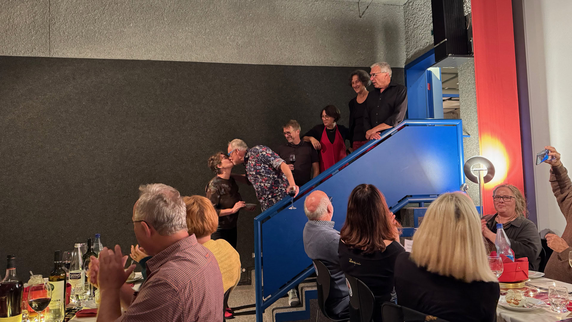 Menschen bei einer Treppenveranstaltung mit Applaus und Gesprächen.