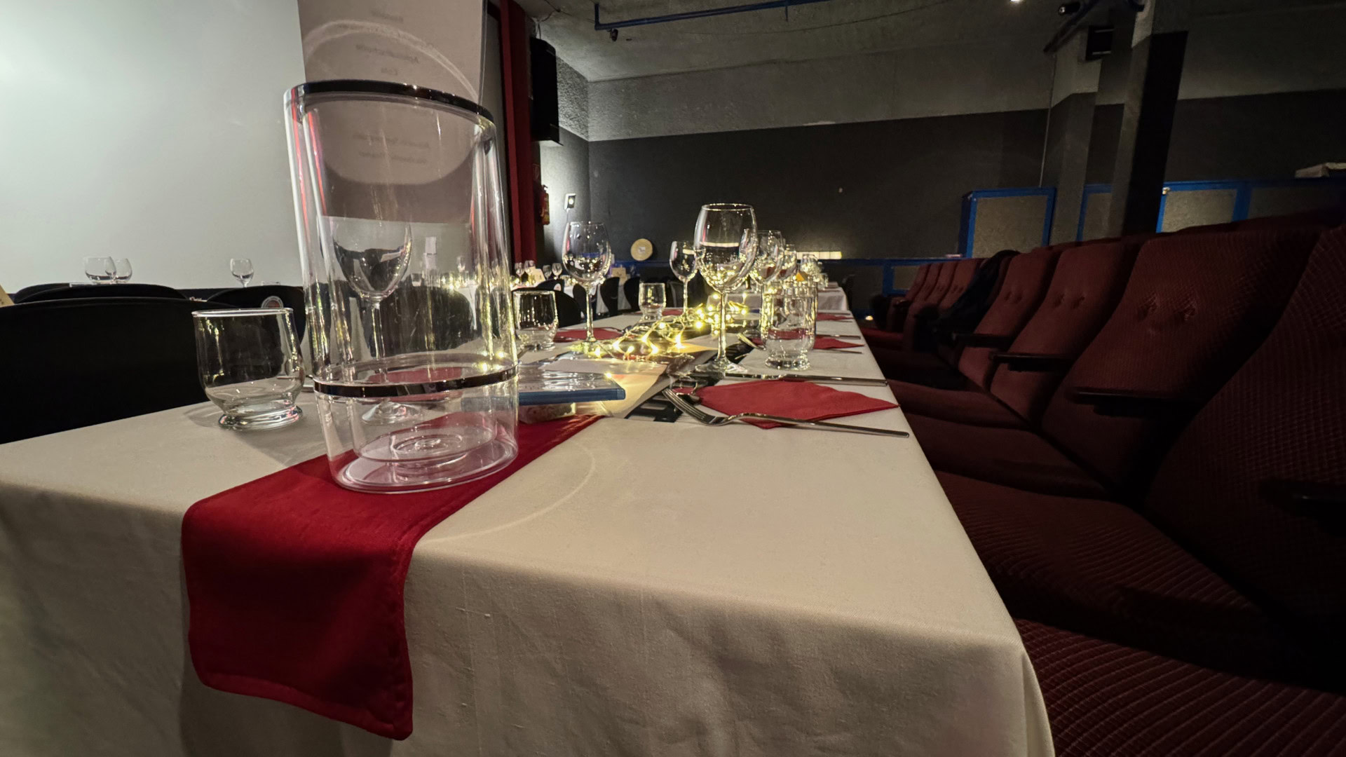 Elegante Tischdekoration mit Gläsern und Lichtern im Saal.