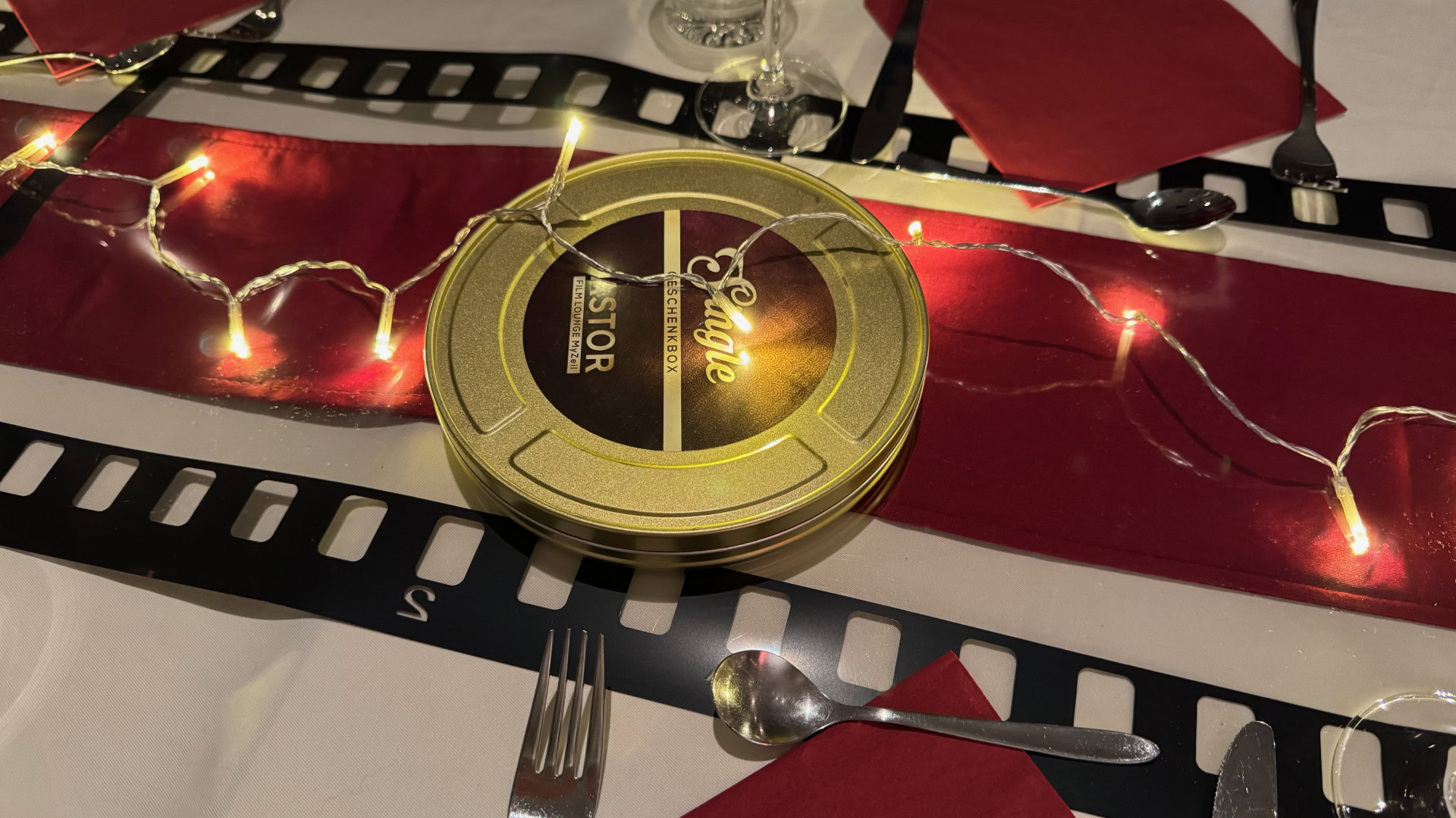Filmspule auf festlichem Tisch mit Lichterkette