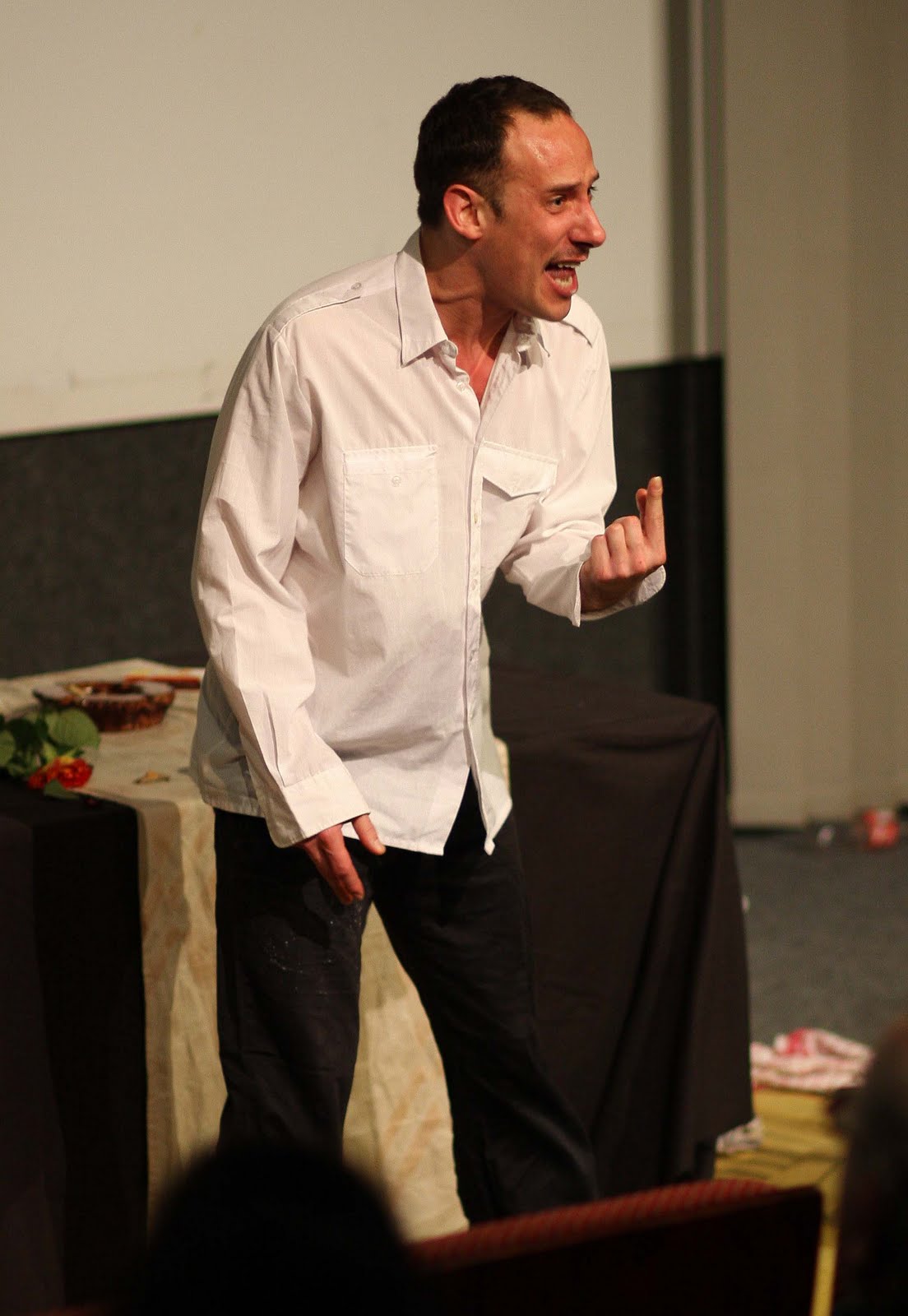 Person in weißem Hemd hält Rede auf Bühne