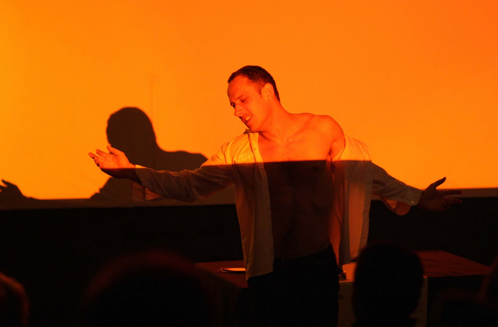 Mann im orangefarbenen Licht auf der Bühne
