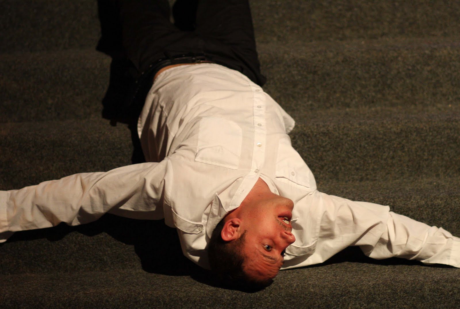 Mann liegt mit ausgestreckten Armen auf Treppe.