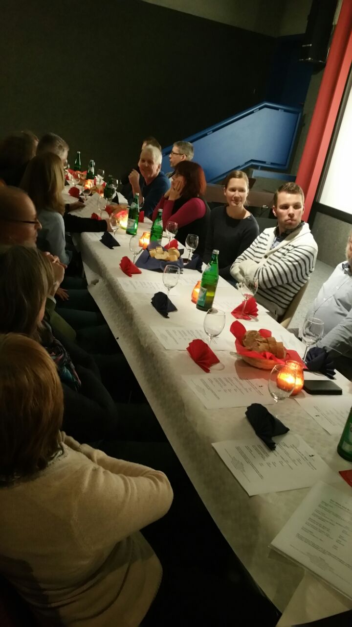 Menschen sitzen an einem gedeckten Tisch.