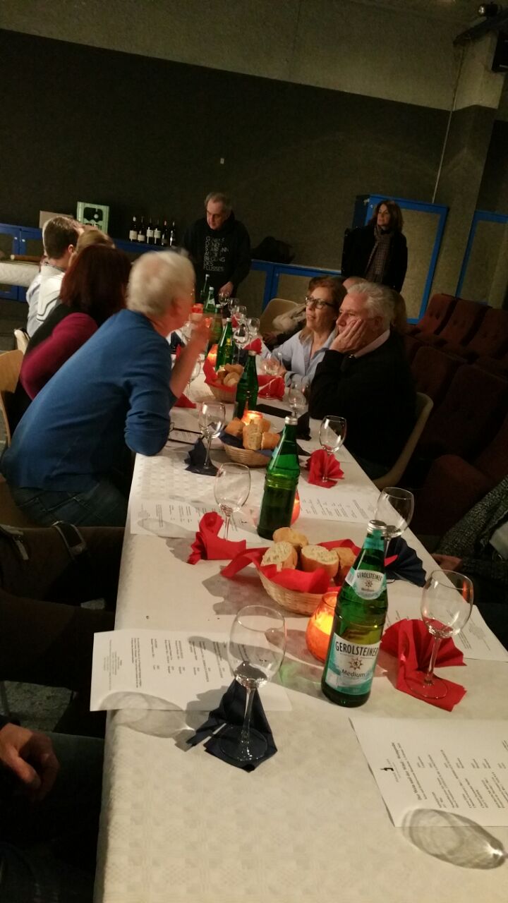 Leute sitzen an einem langen Tisch mit Essen.