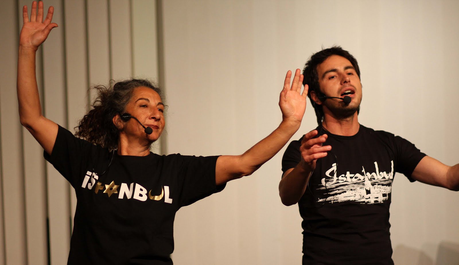 Zwei Menschen singen mit Headsets.