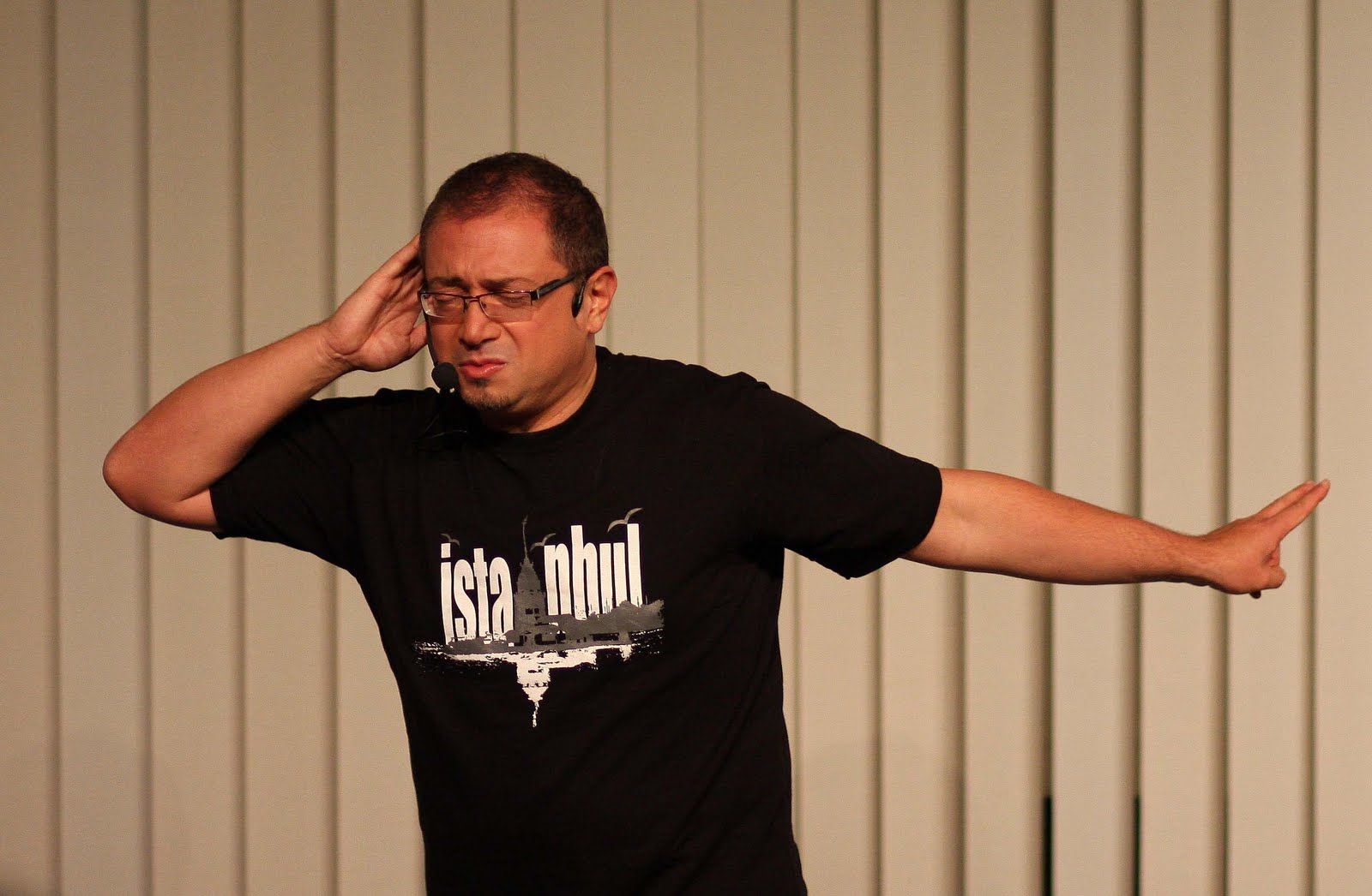 Mann mit Brille und T-Shirt spricht ins Mikrofon