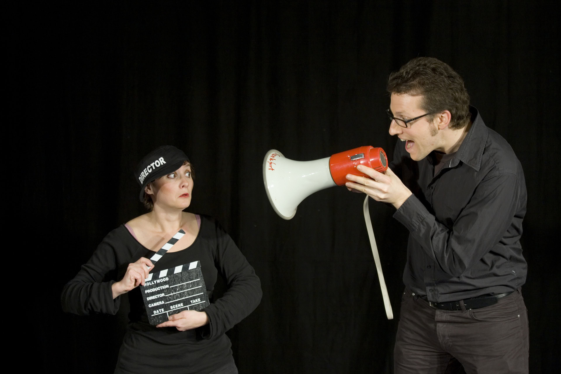 Regisseur mit Megafon und Klappe am Filmset
