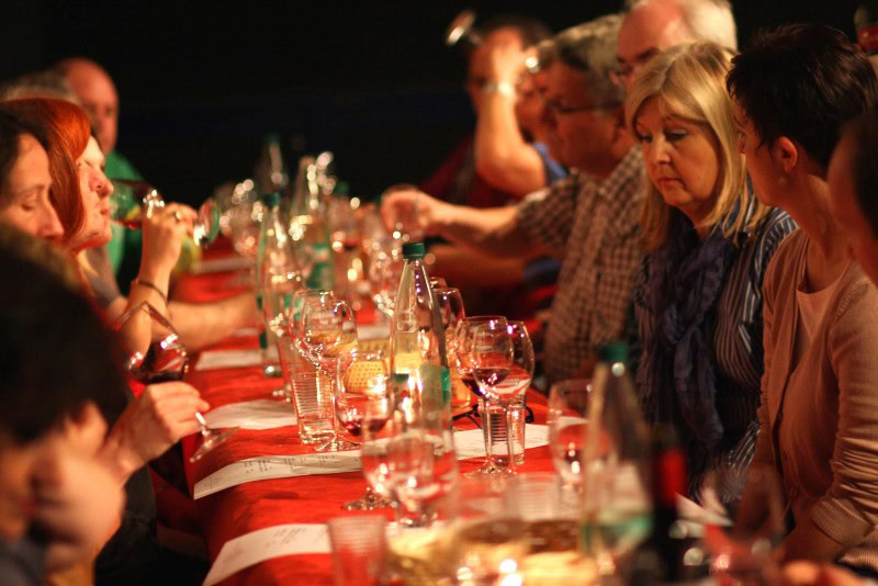 Menschen bei einer Weinprobe am Tisch